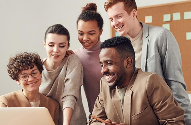 A stock photo of people working around a computer screen