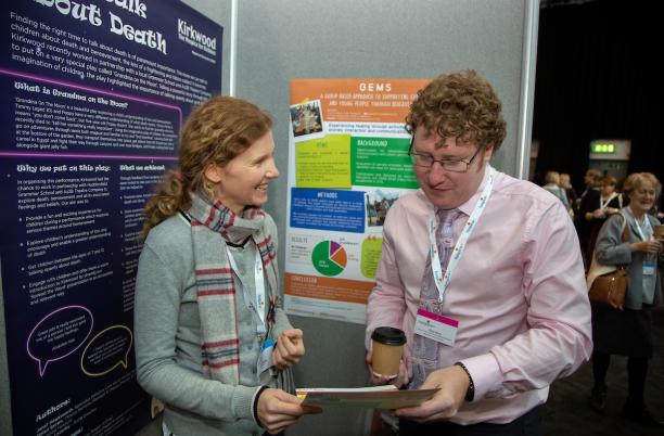Two delegates looking at a poster during the 2019 Hospice UK National Conference