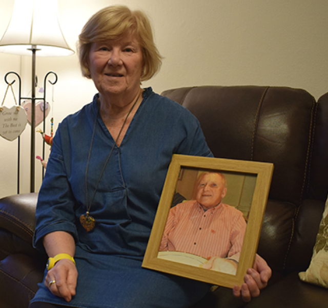 Margaret, holding a picture of her husband Gordon