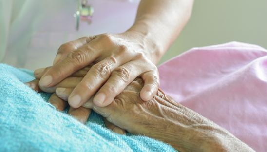 close up of holding hands on a bed