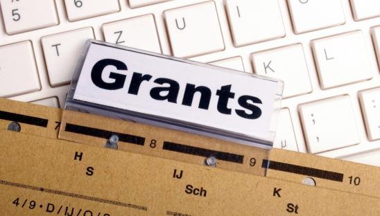A stock photo showing a folder highlighting Grants applications on a keyboard
