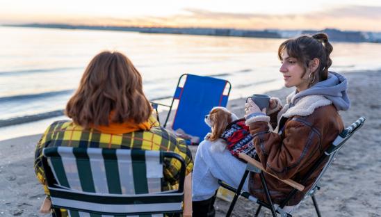 Two women on a beach chatting